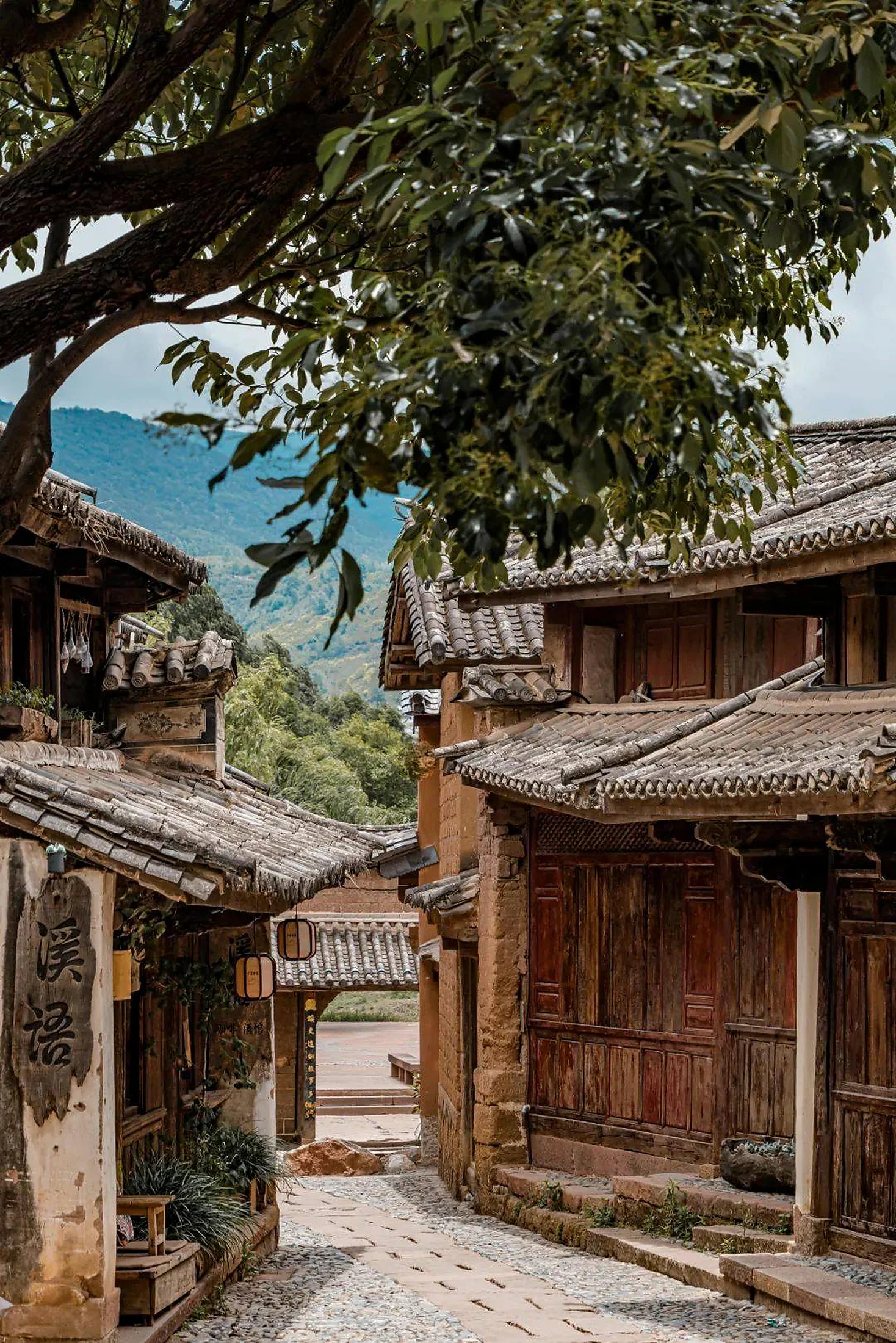 Weathered timber houses and a quiet courtyard lane in Shaxi
