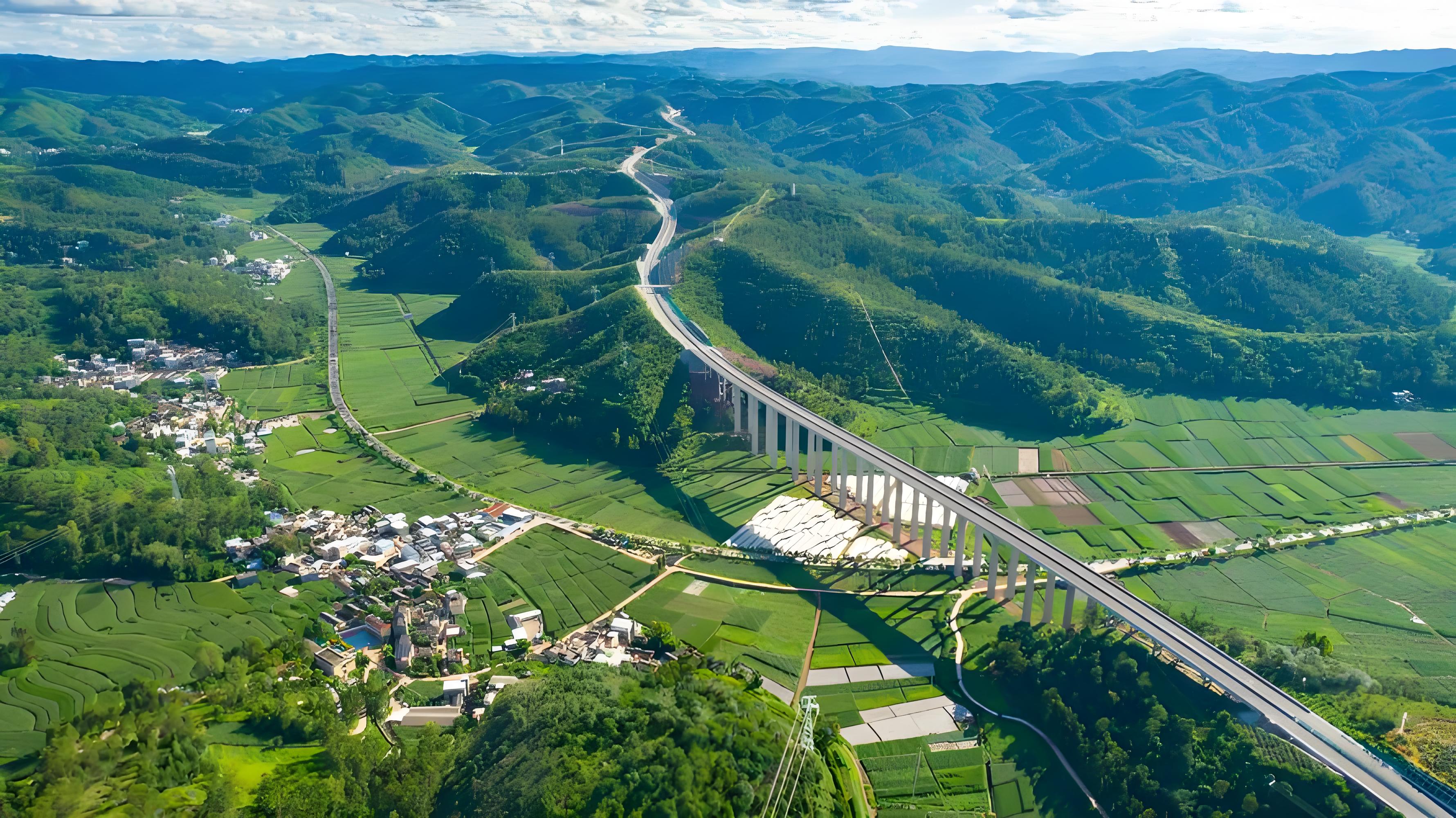 An elevated expressway crossing green farmland and hills in Yunnan