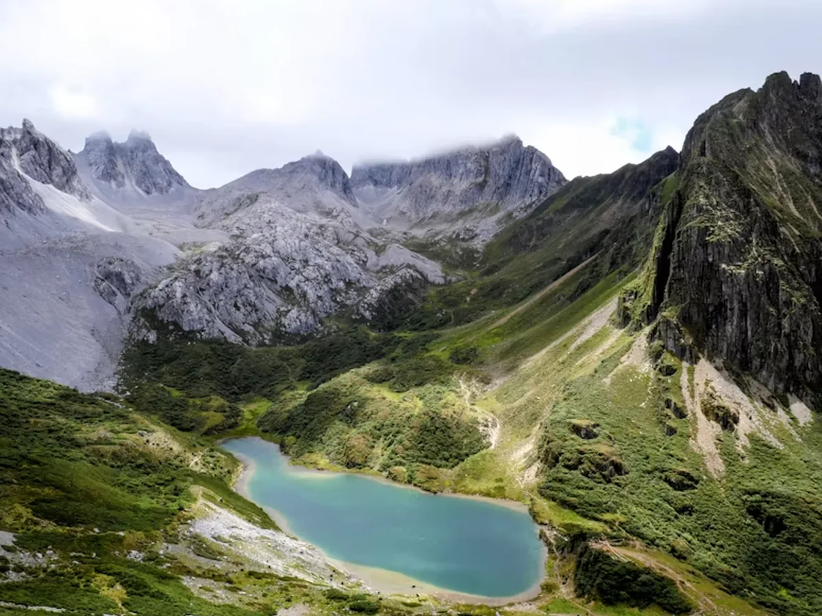 A turquoise alpine lake surrounded by rocky mountains in Yunnan