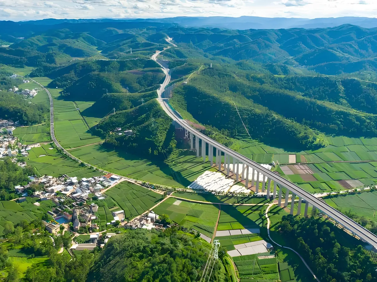 An elevated expressway crossing green farmland and hills in Yunnan